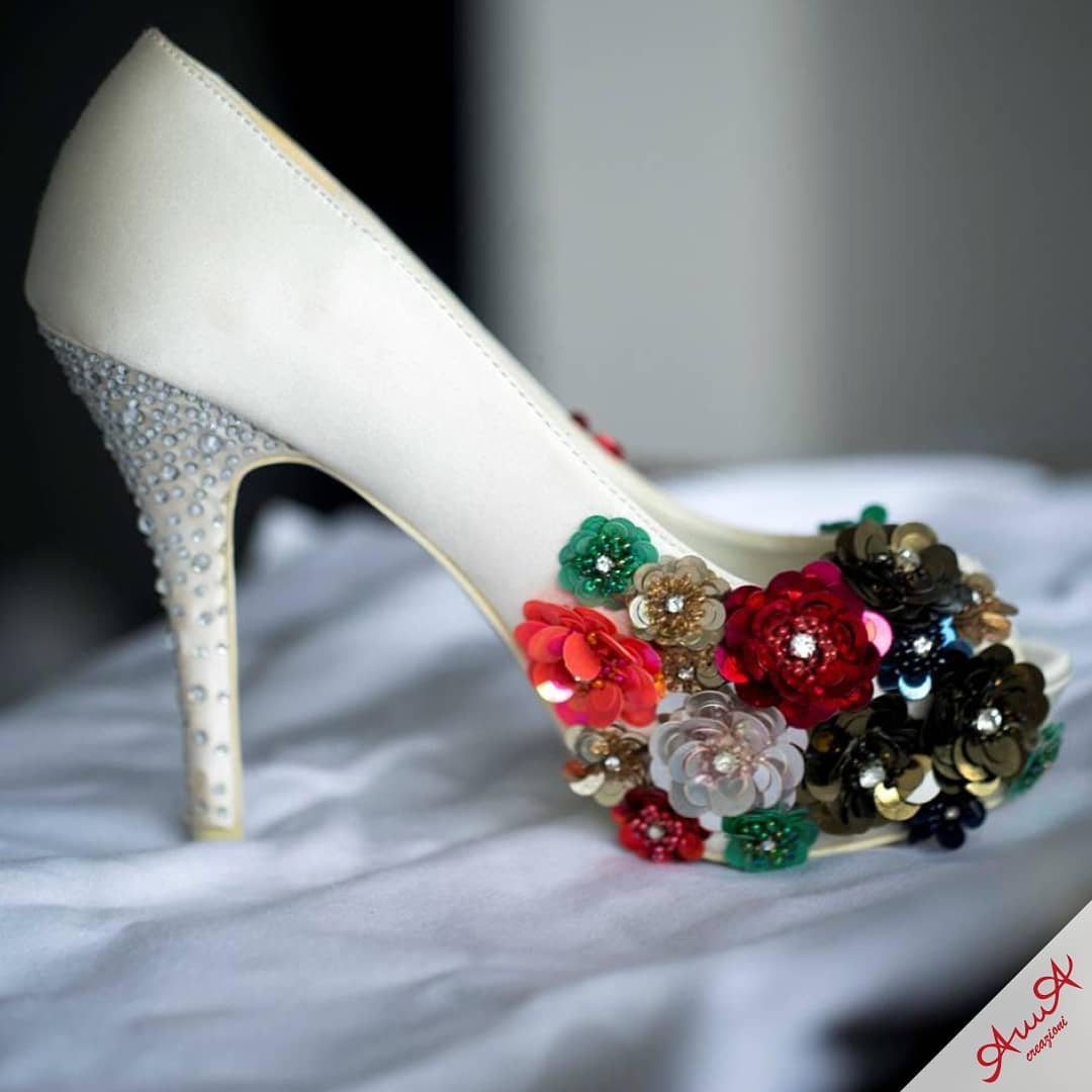 Elegant cream pump featuring a crystal-studded heel and vibrant, multi-colored sequined floral embellishments.