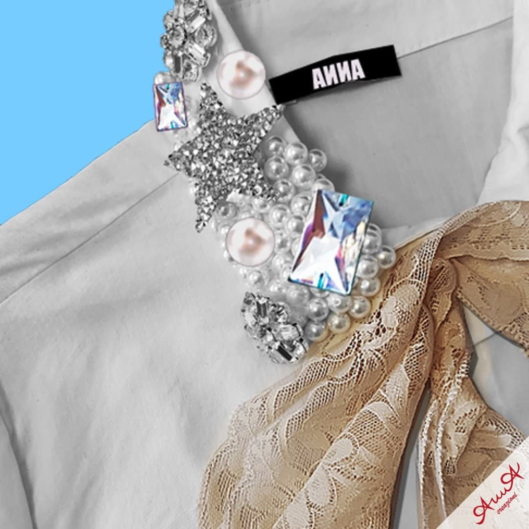 White shirt collar embellished with pearls, crystals, a silver star, and a beige lace bow.